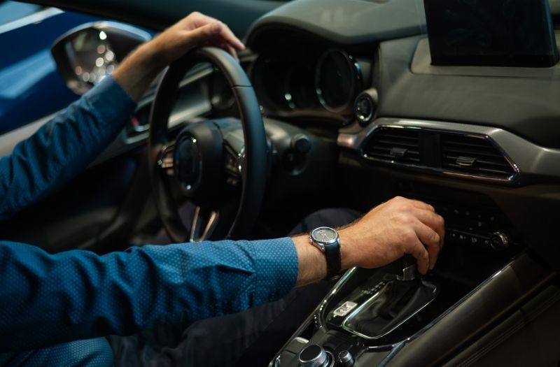 Close-up of a man's hand while shifting the automatic transmission of a car